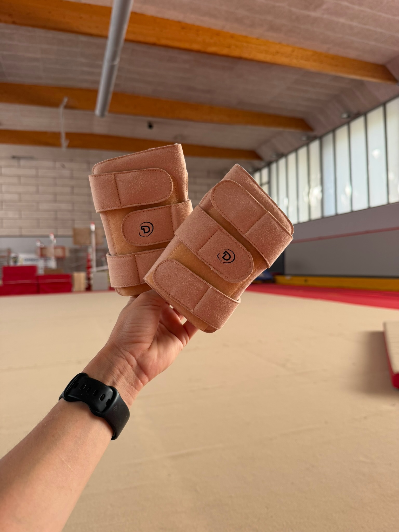 Renforts de poignets semi-rigides DAZZLE présentés dans un gymnase